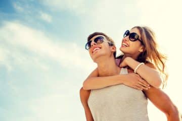 A joyful and romantic moment where a man lifts his partner in his arms